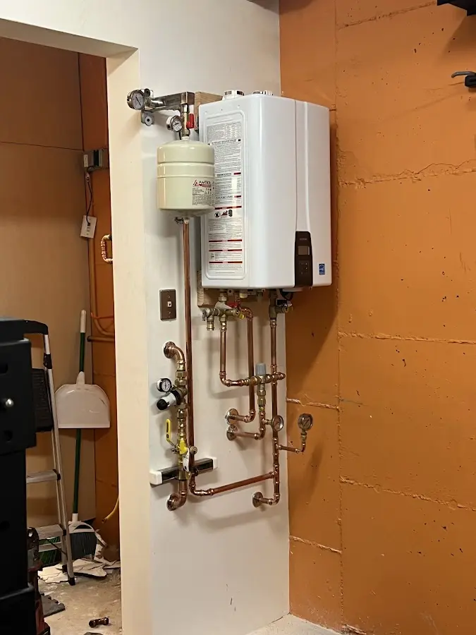 Plumbing technician inspecting water heater connections in Hot Springs